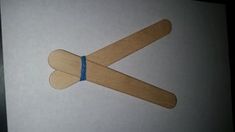 a pair of wooden sticks sticking out of a piece of paper with blue tape on them