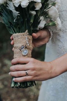 a woman holding a bouquet of flowers in her hands with rings on it's fingers