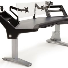 a computer desk with two monitors on it's top and one sitting at the bottom