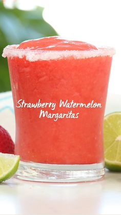 a strawberry and lime smoothie in a glass with strawberries next to it on a table