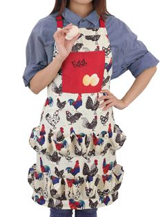 a woman wearing an apron with chickens on it and holding a piece of food in her hand