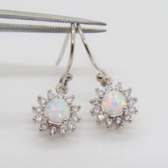 Vintage Sterling Silver White Opal & White Topaz Cluster Drop Earrings...Marked 925...Total of weights 1.8grams...Measure H 7/8'' W 3/8''...These are in very good condition. Sterling Silver Teardrop Jewelry With Halo Design, Sterling Silver Drop Earrings With Bail, Sterling Silver Dangle Earrings With Halo Design, Sterling Silver Halo Design Dangle Earrings, Opal White, Ring Sizer, White Opal, Leaf Earrings, White Topaz