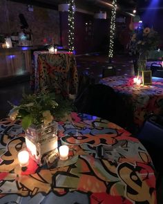 the tables are decorated with colorful cloths and lit candles for an event or party