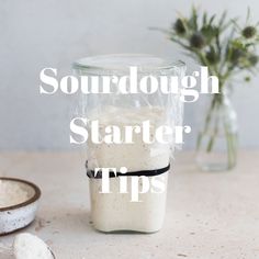 a glass jar filled with white liquid next to a bowl