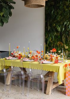 the table is set with yellow cloths and clear acrylic chairs for dinner