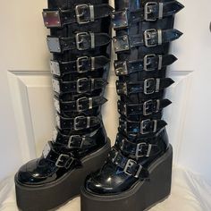 Demonia Knee-High Boots With Lots Of Buckles & Hardware. New In Box, Never Worn. Great Stacks For Long Hours Of Rocking Out. Back Zipper. Platform Heel = 5.5", Front Platform = 3", Boot Shaft ~15", Calf Circumference = ~13" But Is Adjustable With Buckles. #Goth #Halloween #Stacks #Gogo #Punk #Rocker Shoes Demonia, Demonia Shoes, Goth Halloween, Black Platform Boots, Gogo Boots, Punk Rocker, Long Hours, Black Platform, Platform Heel