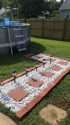 an outdoor swimming pool with stepping stones and gravel