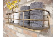 two towels are hanging on a shelf next to a vase with yellow flowers in it