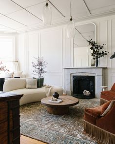 a living room filled with furniture and a fire place in the middle of the room