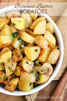 a white bowl filled with potatoes on top of a wooden table