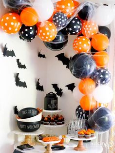 an orange and black halloween dessert table