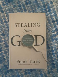 a book that is laying on top of a blue and white table cloth with the title stealing from god