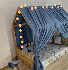 a child's bed with blue drapes and lights