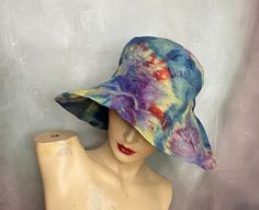 "A big floppy beach hat hand ice tie dyed in blue, green, yellow and red.  It has a drawstring around the inside band to secure fit from the wind.  The hat is by Scala.  The brim is 5\", the crown is 3\", the top diameter is 5 1/2\" and the the inside band is up to 23\" around. Hand or gentle machine wash separately. Excellent condition. Catalog # 8562" Multicolor Beach Hat For Warm Weather, Adjustable Rainbow Hats For Summer, Adjustable Rainbow Summer Hats, Green One Size Bucket Hat For Summer, Summer Green Bucket Hat One Size, Green Bucket Hat For Summer, Multicolor Brimmed Sun Hat For The Beach, Pre-washed Short Brim Summer Hats, Fun Blue Bucket Hat For Vacation