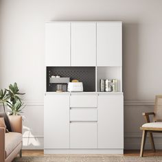 a living room with white furniture and a coffee maker on the cabinet in front of it