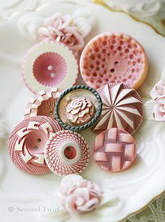 there are many different types of buttons on this plate, all in pink and white