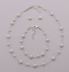 "Perfect for that adorable little girl, this necklace and earrings set features high lister glass pearls and matching Swarovski stud pearl earrings. Necklace is adjustable measuring 12\"-14\" long. Made with durable silver tone cording in a unique \"floating\" design. Choose from four pearl colors. Matching bracelet measures 6 1/2\" and has an extender for additional length. Can be created on a custom jewelry card with your choice of name and font color! All jewelry features high quality electro Pearl Charm Jewelry For First Communion, Adjustable Round Pearl Jewelry Sets, Elegant Pearl White Jewelry For First Communion, Adjustable Round White Jewelry Sets, White Pearl Charm Jewelry For First Communion, White Round Pearl Jewelry Sets, White Round Pearl Chain Jewelry Set, White Pearl Chain Jewelry Set, White Pearl Necklace For First Communion