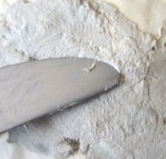 a close up of a knife on a piece of white paper with holes in it