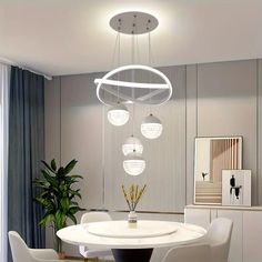 a white dining room table with chairs and a potted plant