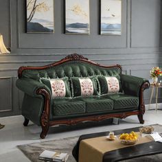 a living room filled with furniture and paintings on the wall next to a coffee table