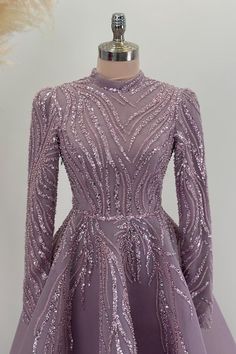 a purple dress on a mannequin dummy with long sleeves and sequins