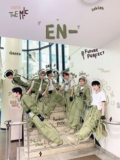 the boys are sitting on some steps in front of a sign that says enf