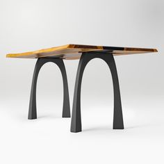 a wooden table sitting on top of a black metal stand with two legs and an upside down piece of wood