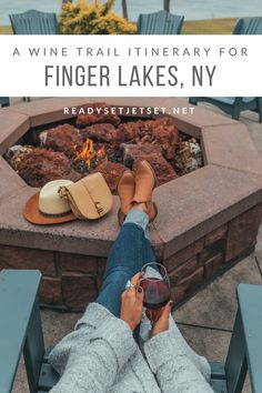 a person sitting in front of a fire pit with their feet up on the table