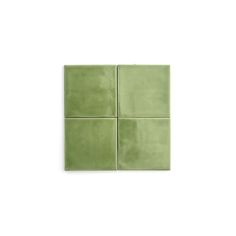 four square tiles in green on a white background, each with different shapes and sizes