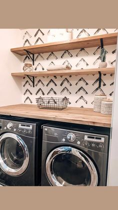 a washer and dryer sitting next to each other on top of a wooden shelf