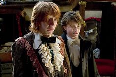 two young men standing next to each other in front of a sign that says, one of the few instances when bow ties are not cool