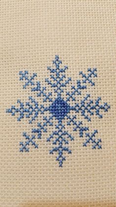 a cross - stitch snowflake is shown in blue