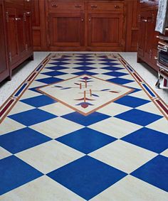 a blue and white checkered floor in a kitchen with cabinets, stoves and microwave