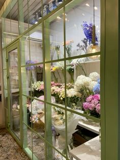 flowers are displayed in the window of a flower shop