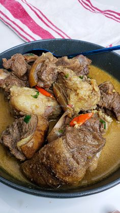 a bowl filled with meat and vegetables on top of a table