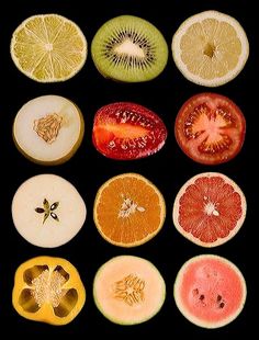 an assortment of fruits cut in half on a black background