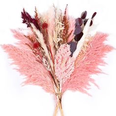 dried flowers are arranged in a vase on a white tablecloth with red and pink feathers