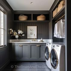 a washer and dryer in a room with dark wood paneling on the walls