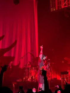 a man standing on top of a stage with his arms in the air