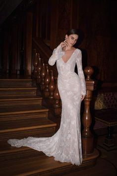 a woman in a white dress standing on some stairs