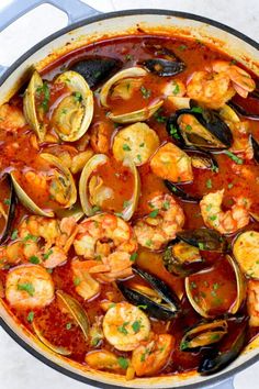 a pan filled with seafood and clams in sauce