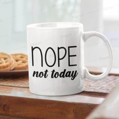 a white coffee mug with the words nope not today on it next to some pretzels