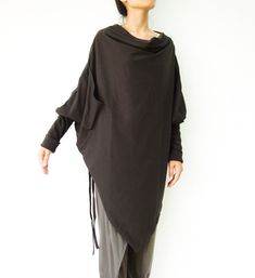 "🚚..ALL ORDERS ARE SHIPPED VIA DHL EXPRESS MAIL This batwing tunic is a very \"cool\" addition to any wardrobe! With a unique drawstrings on bottom hem of tunic provide plenty of options for changing the look. Cowl neckline, batwing sleeves with wide cuffed and oversized side pocket; can be worn layered over leggings, pants, or skirt for even more dramatic effects. * Pull-on style * Cowl neckline * Dropped shoulders * Long sleeves with wide ribbed cuff * Oversize side pocket * Asymmetrical hem Minimalist Clothing, Trendy Sweater, Hot Sweater, Asymmetrical Sweater, Trendy Sweaters, Hem Sweater, Cowl Neck Long Sleeve, Pullover Sweater Women, Sweater Pullover