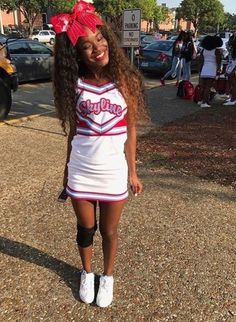 a woman in a cheerleader outfit standing on the street