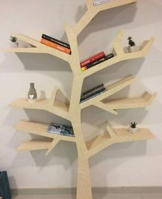 a wooden tree shelf with books on it in the shape of an upside down tree