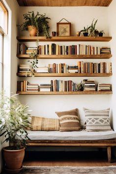 a couch with pillows and books on the shelves