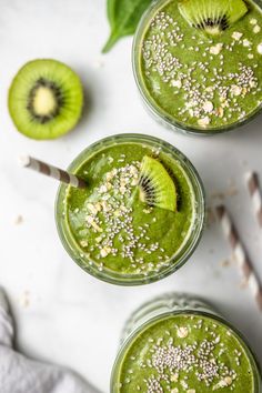 three glasses filled with green smoothie and topped with kiwi