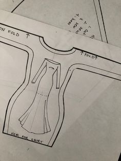 a drawing of a woman's dress is shown on top of a piece of paper