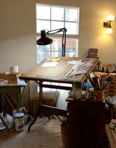 a messy room with lots of clutter on the floor and a desk in front of a window