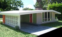 a small model house sitting on top of a lush green field